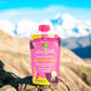 A baby food pouch of Loco Bebe Sweet Potato Paradise organic on a mountain top with organic purple sweet potato organic banana and organic passion fruit and lime